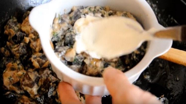 We shift the julienne into cocotte mills, grease the sour cream on top and send it to the oven.