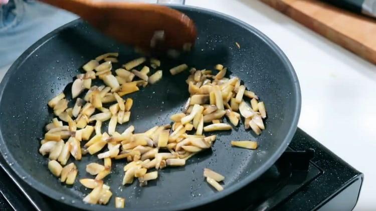 Fregiu els bolets en una paella.