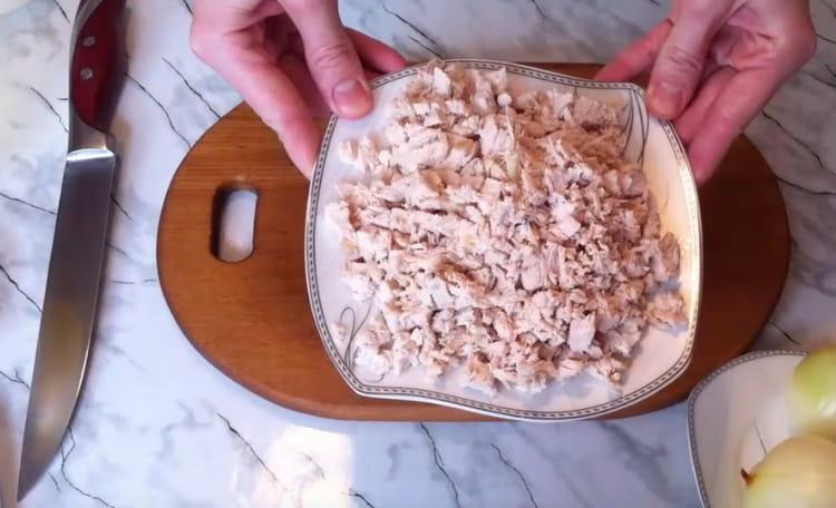 Couper le filet de poulet bouilli en morceaux.