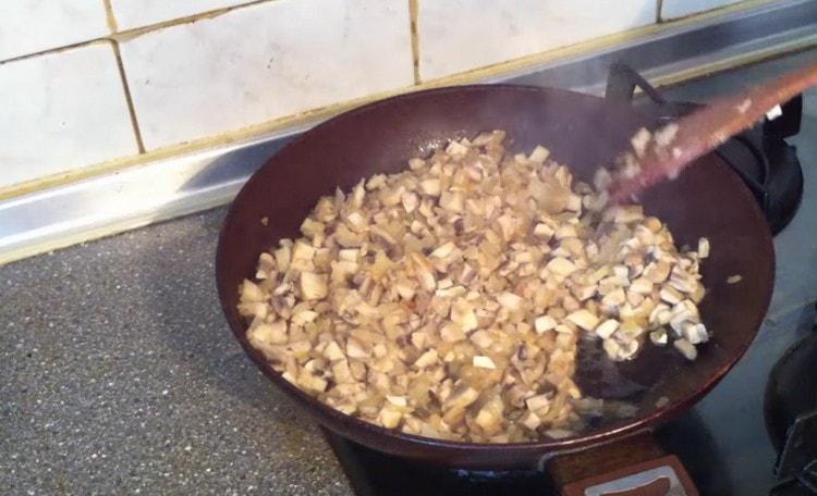 Agregue los champiñones a la sartén a la cebolla.
