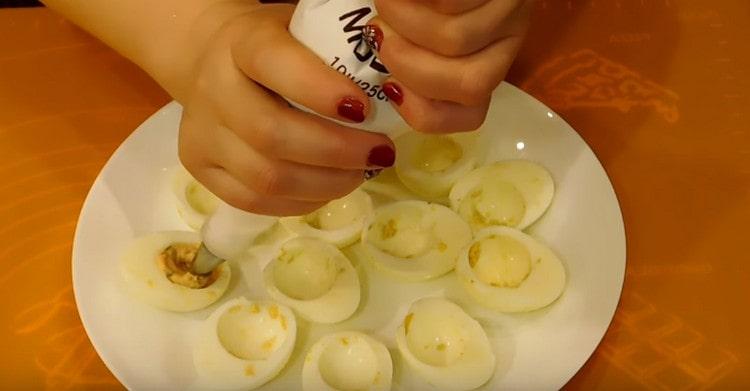 À l'aide d'une poche à pâtisserie, nous farcissons les blancs d'œufs avec la masse cuite.