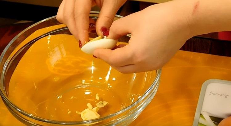 couper chaque œuf en deux et retirer délicatement les jaunes.