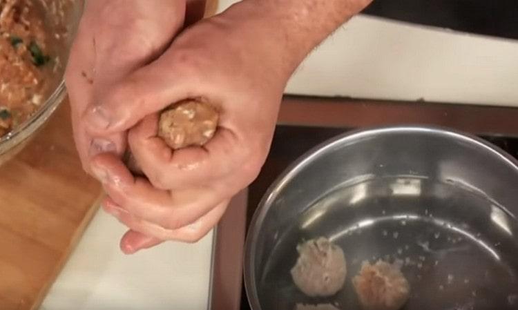Nous formons des boulettes à partir de viande hachée et nous les mettons dans de l'eau bouillante.