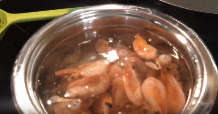 Nous mettons les crevettes congelées dans de l'eau bouillante.