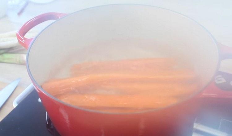 Nous répandons les carottes dans de l'eau bouillante.