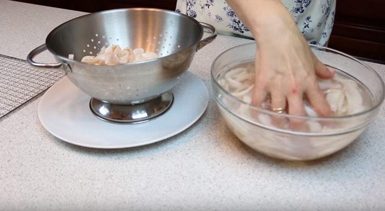 We shift the squids to a colander, let the liquid drain.