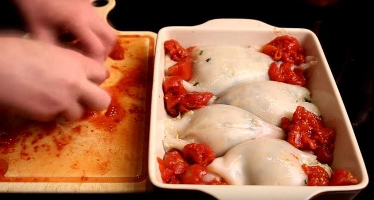 Coupez finement les tomates en conserve et répartissez-les entre les calmars.