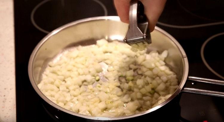 Put the onion in the pan, squeeze the garlic.