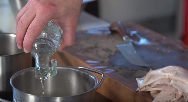 Mettez l'oignon dans une casserole, ajoutez la feuille de laurier, les grains de poivre et l'huile végétale.