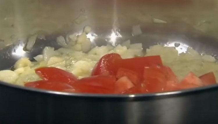 Agregue los tomates en rodajas a la cebolla.