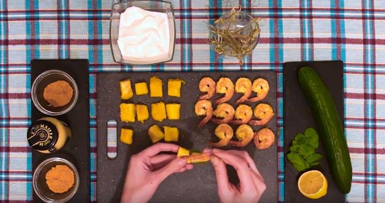 En un pincho ensartamos camarones, una hoja de menta y una rodaja de mango.