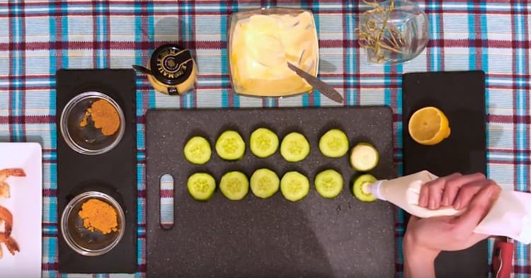 Pressez la crème de moutarde à la crème sure sur chaque cercle de concombre.