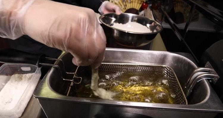 Gently lower the shrimp into boiling oil.