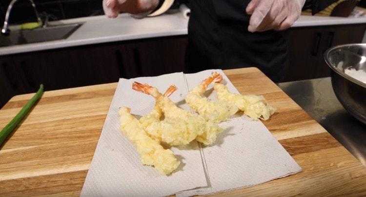We shift the shrimp onto napkins to remove fat.