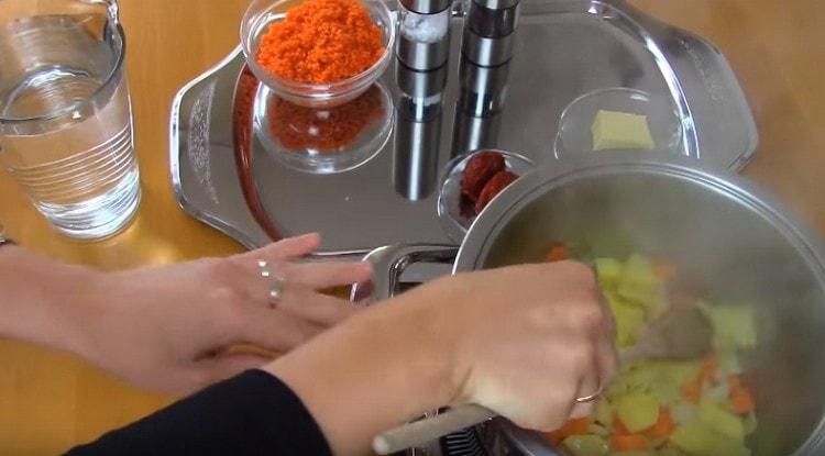 ponga cebollas picadas al azar, zanahorias y papas en una cacerola.