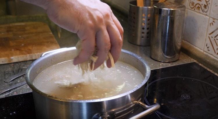 Cuando las verduras estén listas, regrese la carne a la sopa y agregue los fideos.