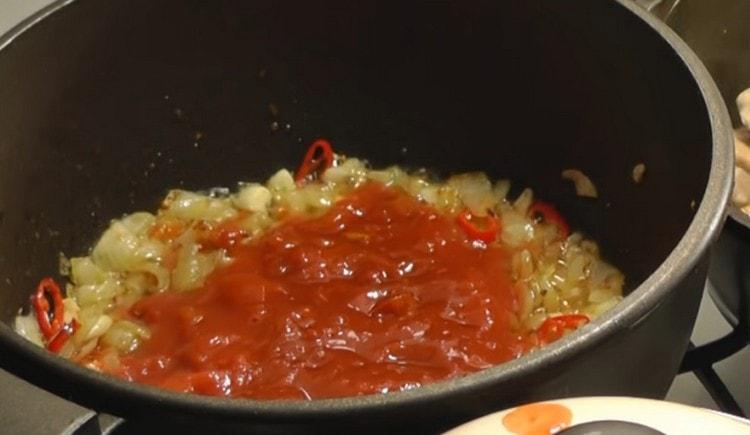 Agregue tomates a la cebolla en nuestro propio jugo.