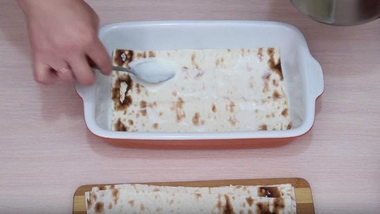 Extendemos la hoja de pan de pita, engrasa con salsa de leche.