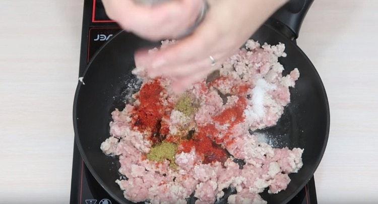 Voeg kruiden en tomatenpuree toe aan het gehakt.