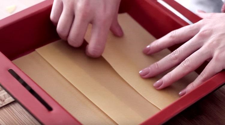 At the bottom of the baking dish we lay out the sheets of lasagna.