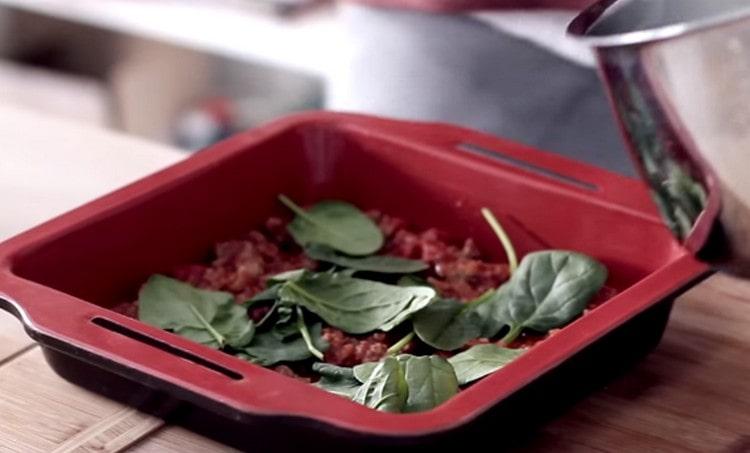 Spread basil leaves on top of the sauce.