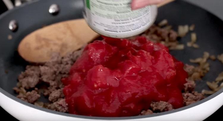 Add canned tomatoes to the minced meat.