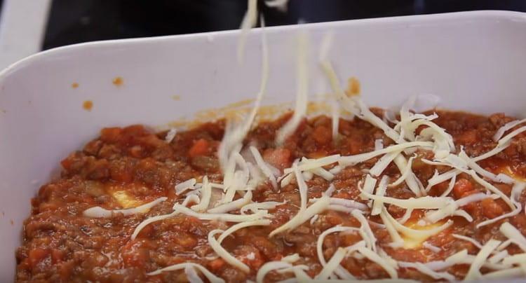 The next layer is making Bolognese sauce and sprinkle it all with grated cheese.