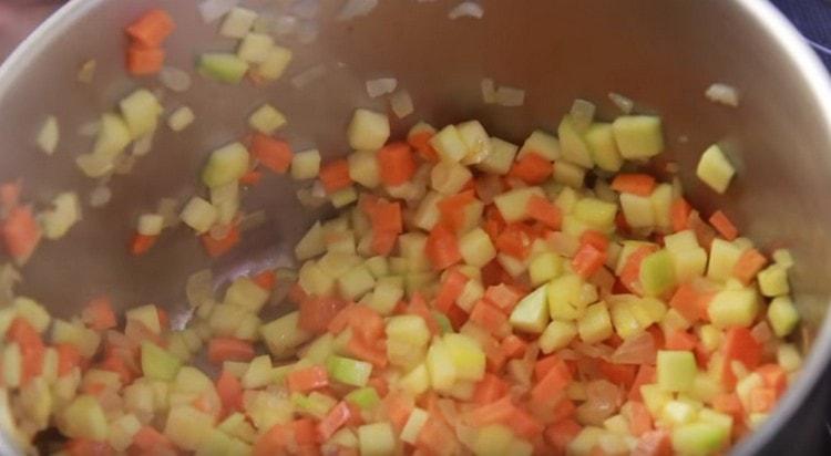 Agregue las zanahorias, el calabacín y las verduras a fuego lento.