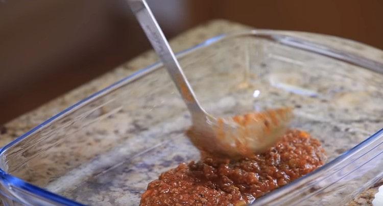 At the bottom of the baking dish we spread the bolognese sauce.