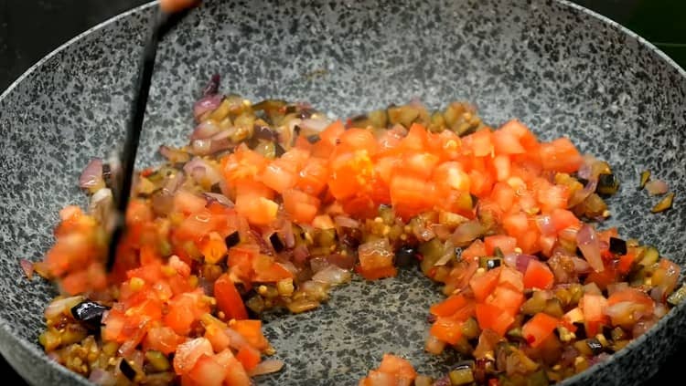 Add tomatoes to the eggplant.