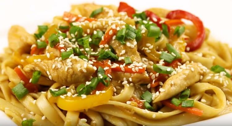 Wok noodles with chicken will be more effective when served if sprinkled with greens and sesame seeds.