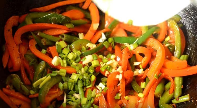 Add chopped green onions to the vegetables.