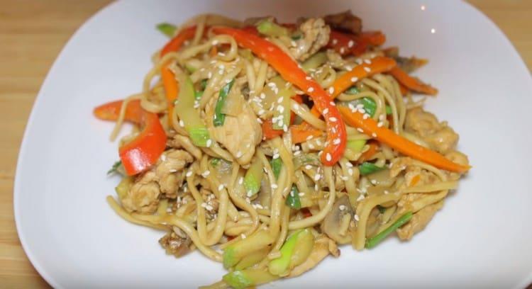 Udon noodles with chicken and vegetables will look even more appetizing if sprinkled with sesame seeds when serving.