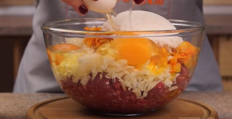 La carne picada, el repollo, las cebollas con zanahorias y el arroz se combinan en un tazón, agregue los huevos.
