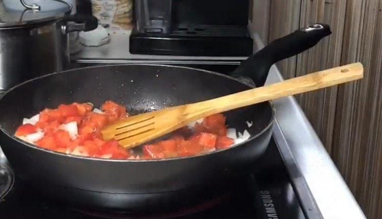 Agregue los tomates a la cebolla en la sartén.