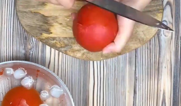 Cambiamos los tomates después de hervir agua en agua helada y los pelamos.