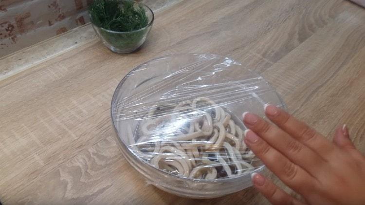 Tighten the squid bowl with cling film and put in the refrigerator.