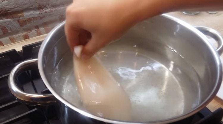 We boil water in a saucepan, salt it and spread the squid.