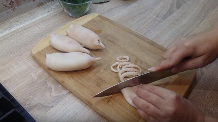 cut boiled squids into rings.