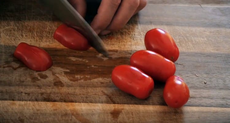 Cortar los tomates cherry en cuartos.