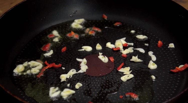 faites d'abord frire l'ail et le poivre dans une poêle avec de l'huile d'olive.