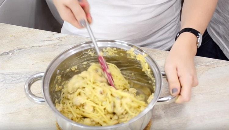 Revuelva los espaguetis preparados con nuez y salsa de champiñones.