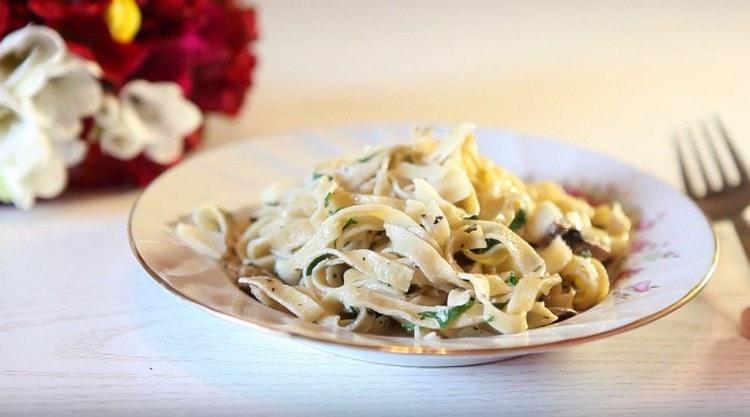 Appetizing pasta with mushrooms in a creamy sauce is ready.