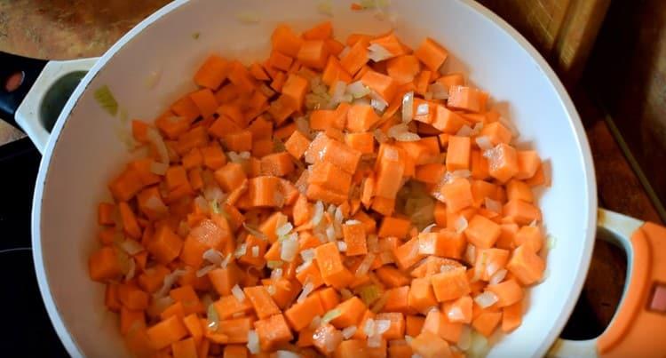 Agregue zanahorias a la cebolla suave.