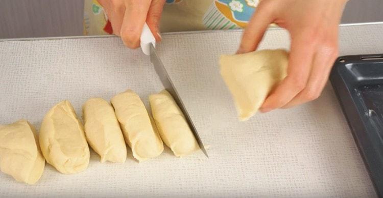 Nous divisons la pâte en deux parties, roulons chacune d’elles avec un rouleau et divisons en portions.