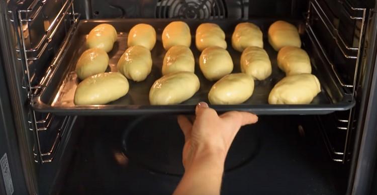 We send a baking tray with pies into the oven.