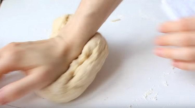 Puis en ajoutant un peu plus de farine, pétrir la pâte sur la surface de travail.