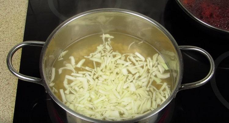 Dans une casserole avec des haricots, étalez le chou.