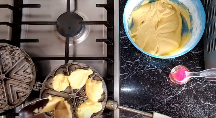 We spread the dough into the cells of the waffle iron and close it.