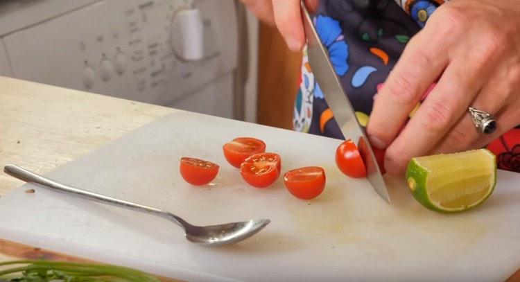 Cherry tomatoes are cut in half and sent to the pan.